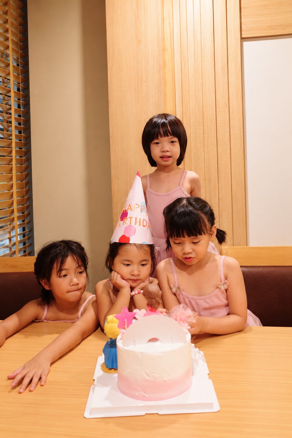 Sofi and the children in her family gathered around a birthday cake