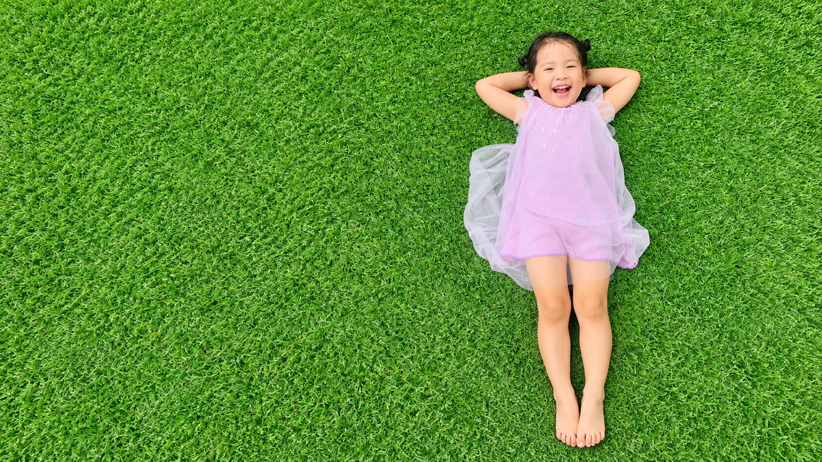 Sofi, Trương Nhã Lâm, lying on a green lawn, shown from head to toe